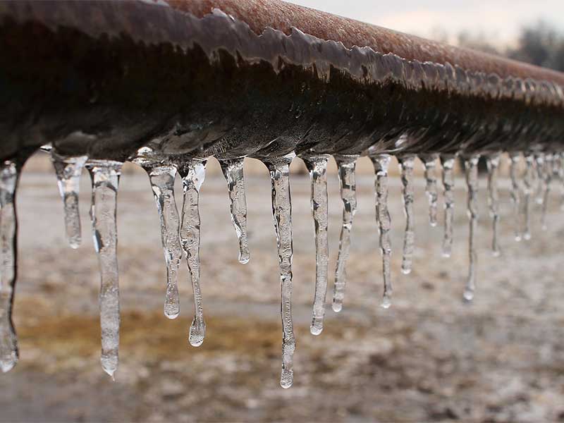 Icicles hanging from frozen pipe.